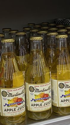 several bottles of apple juice on display in a store