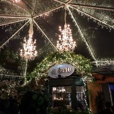 an umbrella covered in lights and greenery with the word la cado on it