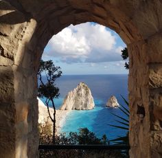 an arch opening into the ocean with blue water