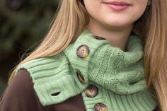 a woman with long blonde hair wearing a green sweater