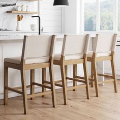 three chairs are lined up in front of the kitchen counter