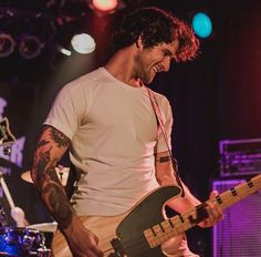 a man playing guitar on stage at a concert