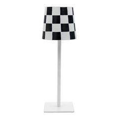 a black and white checkered lamp on a stand