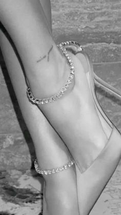 black and white photo of woman's feet wearing high heels with chains on them