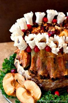 an elaborately decorated cake on a plate with apples and cranberries