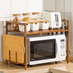 a microwave oven sitting on top of a wooden shelf next to a counter filled with food