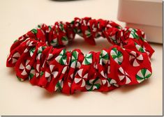 a close up of a red and green hair tie on a white table next to a computer