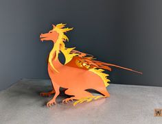 a paper sculpture of a dragon on a table