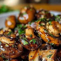 mushrooms with sauce and herbs on a white plate