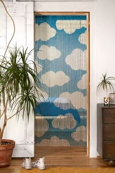 a blue and white patterned door covering in front of a potted plant on the floor