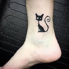 a small black cat tattoo on the ankle