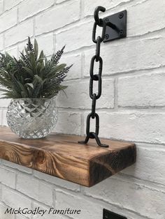 a potted plant sitting on top of a wooden shelf next to a white brick wall