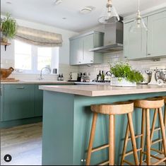 two wooden stools sit at the center of a kitchen island