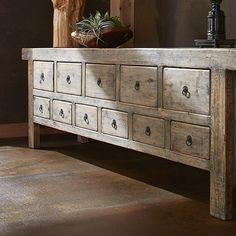 an old wooden dresser with many drawers and plants sitting on it's top shelf