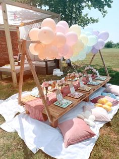 a picnic table with balloons and food on it