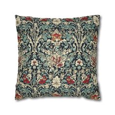 a blue and red pillow with an ornate design on the front, sitting on a white background