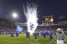 the football team is running onto the field with fireworks in the air and on to the field