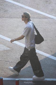 a man walking down the street carrying a bag