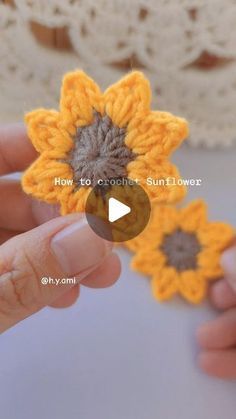 someone is holding two crocheted sunflowers in their hands, with the video below