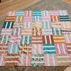 a patchwork quilt sitting on top of a wooden floor