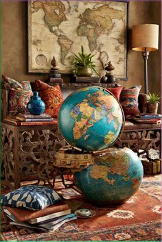 an old world globe sitting on top of a table next to pillows and a lamp