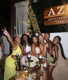 a group of women posing for a photo in front of a sign that says az restaurant