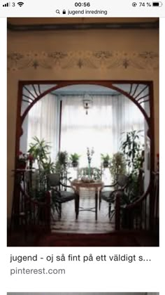 an open door leading to a dining room with potted plants on the table and chairs