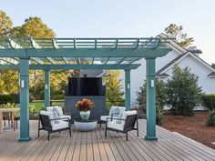 an outdoor living area with chairs, table and television