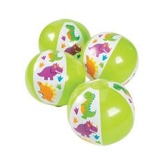 four green and white balls with dinosaurs on them