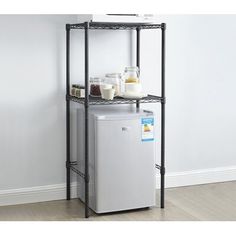 a black shelving unit with a refrigerator next to it