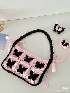 a crocheted purse and matching hair clips on a white table with pink ribbon