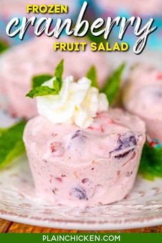 frozen cranberry fruit salad on a white plate with mint leaves and whipped cream