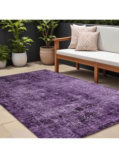 a purple rug on the ground in front of a couch and some potted plants