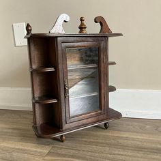 an old wooden cabinet with glass doors on the front and bottom shelves is sitting in a room