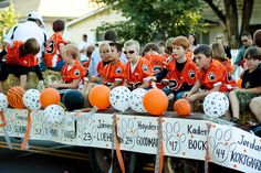 a group of young boys sitting on the back of a truck with orange and white balloons