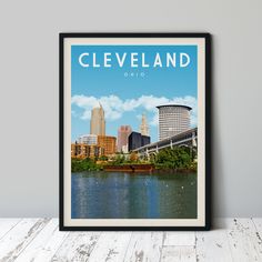 the cleveland skyline is framed in black on a white wooden table next to a gray wall