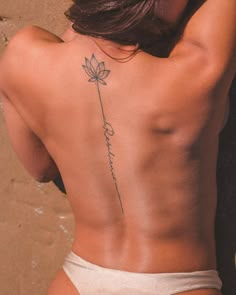 the back of a woman's body with a tattoo on her lower back and side