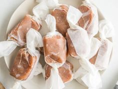 several pieces of food wrapped in plastic on a white plate with utensils next to it