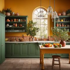 an orange kitchen with green cabinets and plants on the countertop, in front of a window