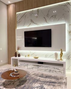 a living room with a large tv mounted on the wall and a table in front of it