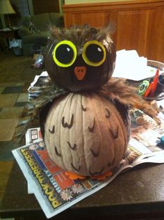 an owl sitting on top of a paper lantern with large eyes and feathers around its body