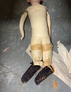 an old worn out doll laying on the ground