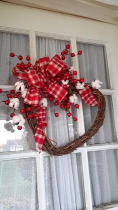 a heart shaped wreath hanging on the front door