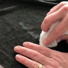 an older woman is cleaning her hands with a cloth on top of a black blanket