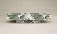 a green marble bowl sitting on top of a table