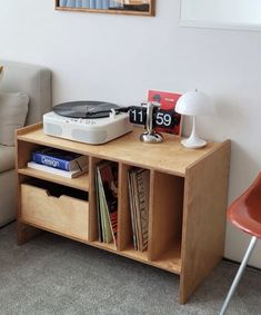 a record player sitting on top of a wooden table next to a couch and chair