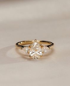 a yellow gold engagement ring with three pear shaped diamonds