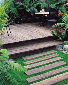 a wooden deck surrounded by lush green plants