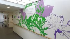 an office hallway with flowers painted on the wall