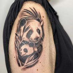 a man with a panda bear tattoo on his arm and shoulder is holding a baby panda